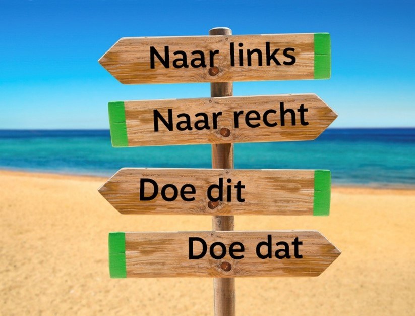 op het strand staat een wegwijzer met vier pijlen, naar links, naar rechts, doe dit, doe dat