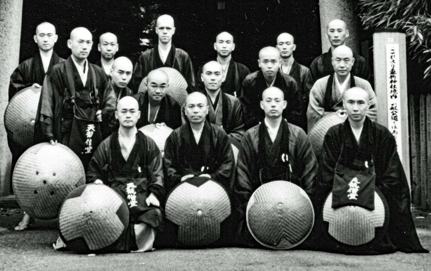 16 zenmonniken poseren op een groepsfoto tijdens een bedeltocht in Kyoto in 1987, allen hebben een ronde strohoed, achteraan staat Rients, die uitsteekt boven de anderen, omdat hij nu eenmaal langer is