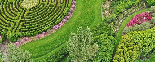 hoogtefoto van een tuin, links bovenin is een groen labyrinth te zien