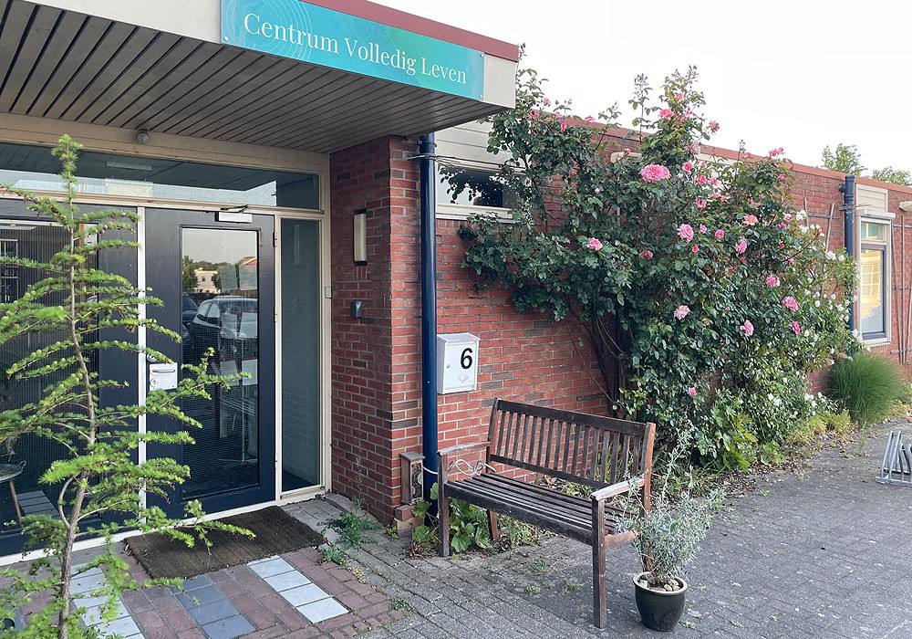 ingang centrum volledig leven in Zutphen, rechts naast de ingang bloeit een roze roos